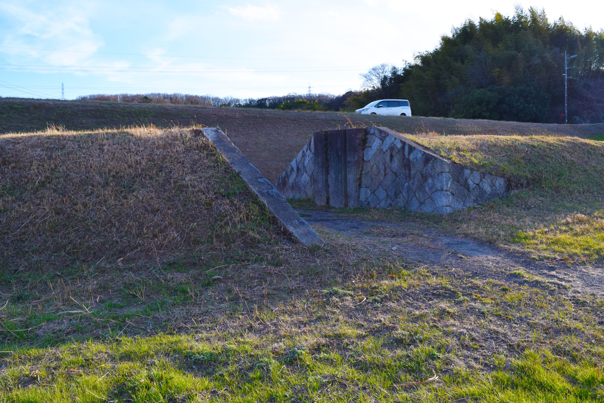 背後で車が走っている場所が現在の堤防です